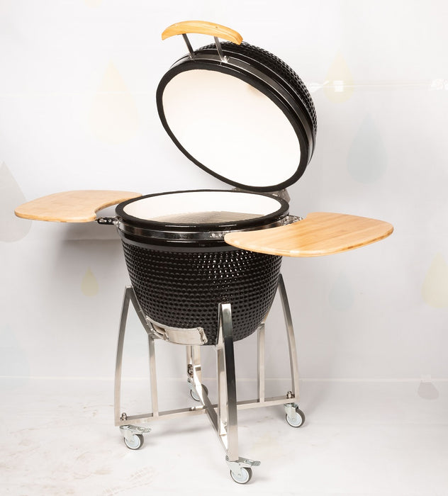 Black ceramic kamado-style BBQ with dome lid and steel frame on wheels