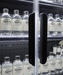 Black wall mounted four door refrigerated display case with LED lit interior and five shelves view 4